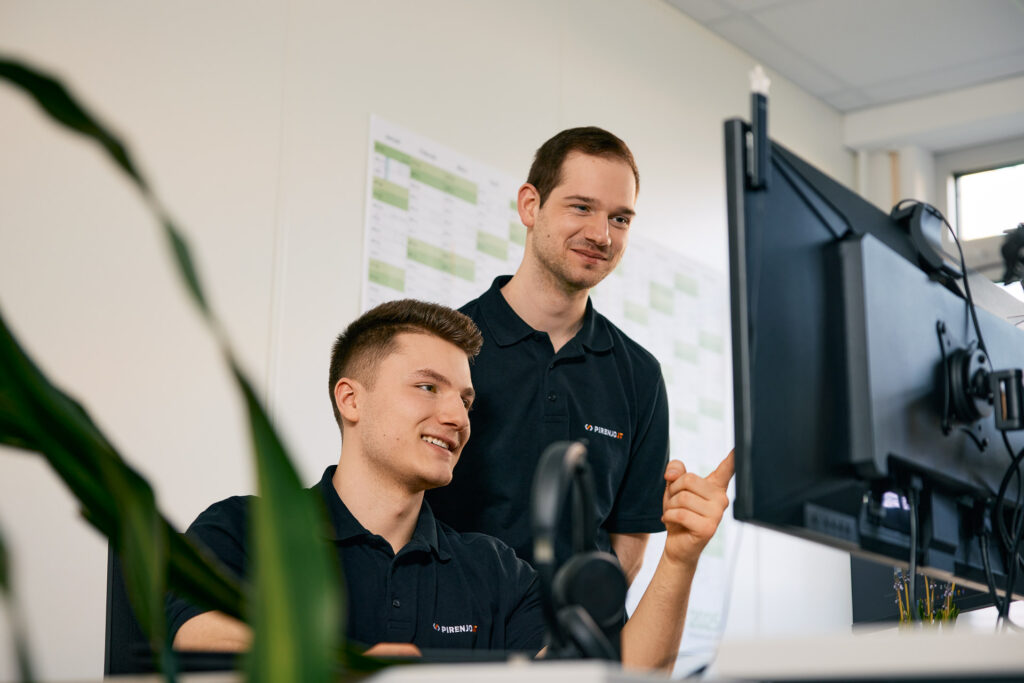 Mitarbeiterin und Kollege analysieren Bildschirmdaten.