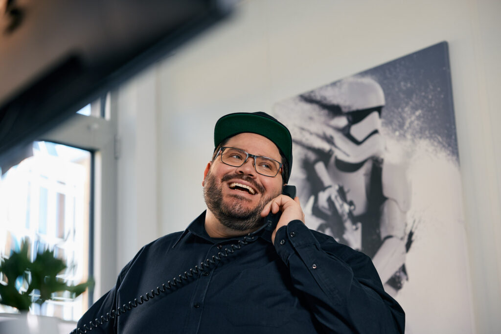 Kollege lacht entspannt im Büro.