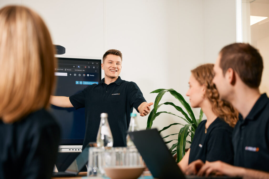 Mitarbeiter präsentiert Inhalte vor der Gruppe.