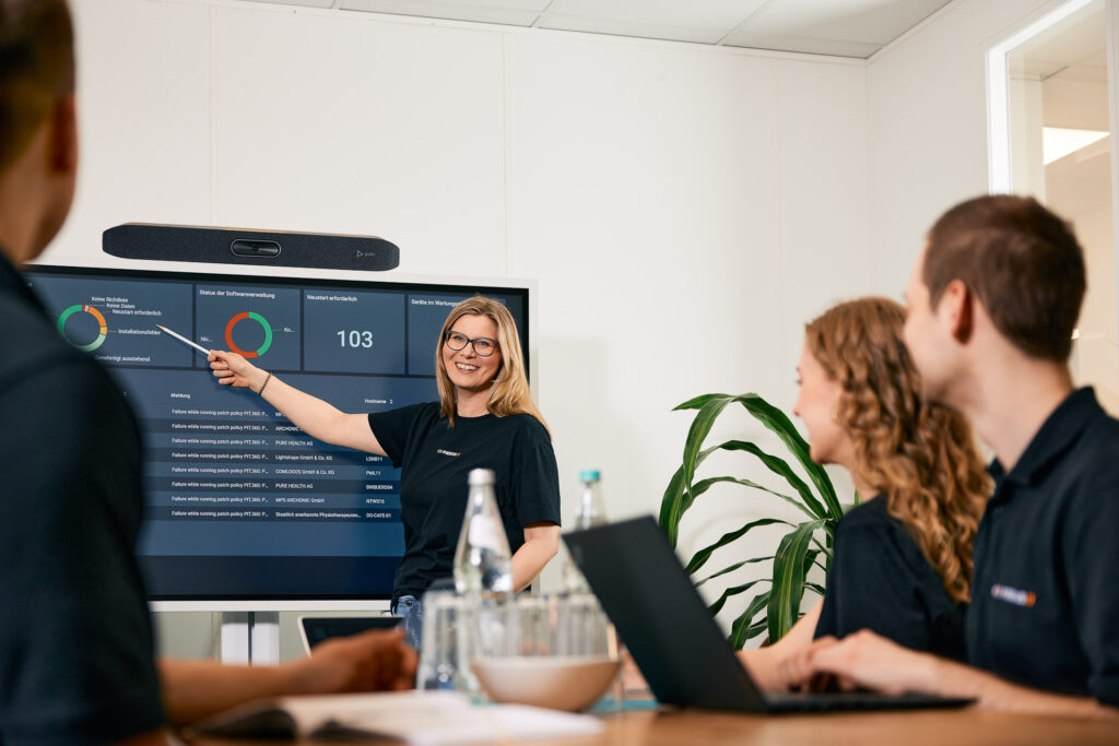 Mitarbeiter präsentiert Inhalte vor der Gruppe.