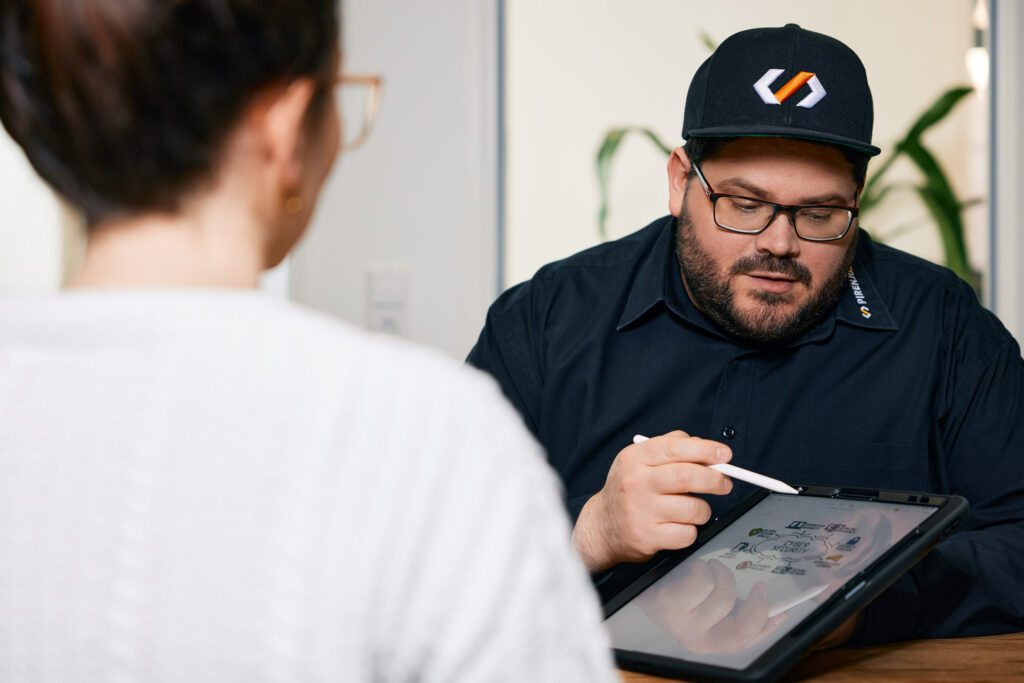 Mitarbeiter erklärt am Tablet im Meeting.